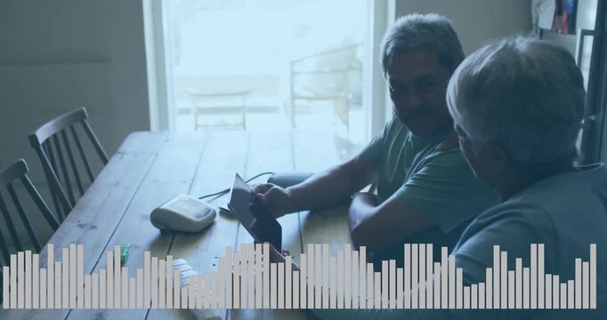 Senior couple analyzing blood pressure data on tablet at wooden table while heart chart floating