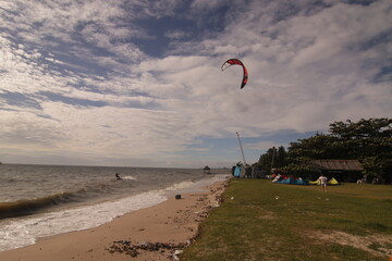 에메랄드빛 바다 위에서 시원하게 바람을 가르며 카이트 서핑을 즐기는 역동적인 해양 스포츠 풍경
