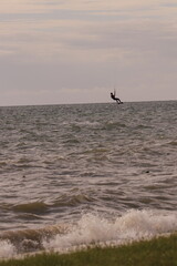 에메랄드빛 바다 위에서 시원하게 바람을 가르며 카이트 서핑을 즐기는 역동적인 해양 스포츠 풍경
