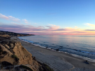 Obraz premium Beautiful Sunset Over the Coastal Beach with Calm Waters in Irvine, California