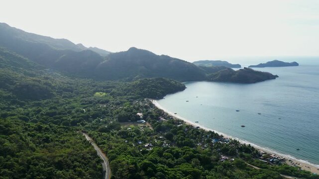 Wide daytime summit panorama showcasing dramatic rock monolith, blue skies, and lush coastal mountains at Pico De Loro Nasugbo Batangas Philippines