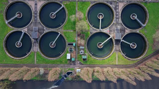 Aerial drone view of the massive Coleshill Sewage Treatment Works near Birmingham, featuring circular clarifier tanks and digestion ponds.