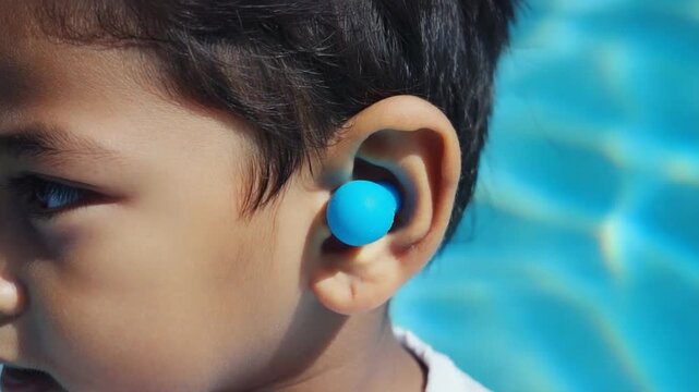 Child with earplugs in a swimming pool.