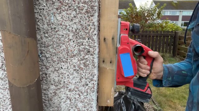 An electric planer cutting a board. A close-up side view. A craftsman using an electric planer. Interior renovation. Interior restoration and refurbishment. Home improvement.