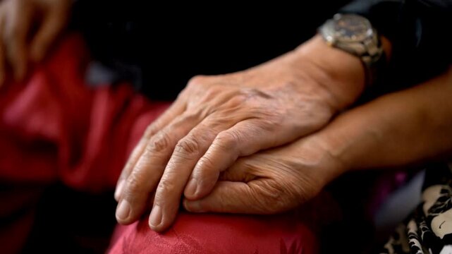 View of senior man's hands caressing and holding senior woman's hands. Affectionate elderly couple holding hands. Senior husband hold his wife's hands.