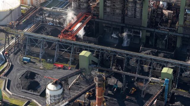 Detailed aerial perspective of petroleum coke production and heavy industry chemical pipework at the Humber refinery complex UK