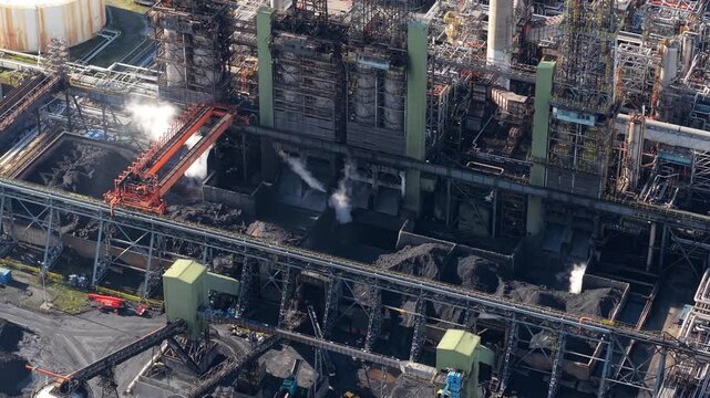 Detailed aerial perspective of petroleum coke production and heavy industry chemical pipework at the Humber refinery complex UK