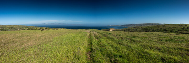 Obraz premium Trail To Carrington Point Cuts Through Open Field With Santa Cruz In The Distance