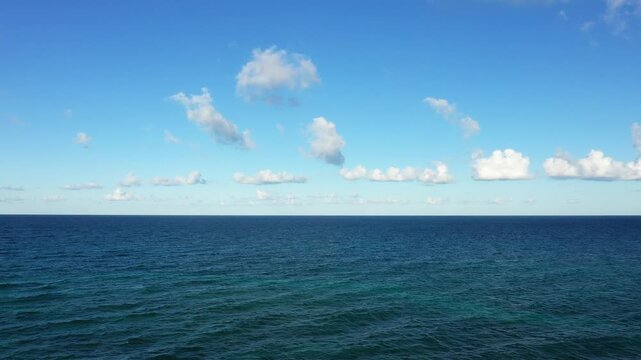 Tranquil view of the open sea under a clear blue sky with scattered clouds, captured near Brindisi, Italy.
