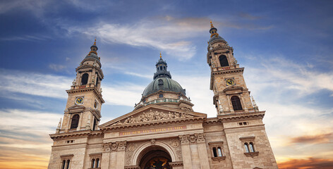 St. Stephen's Basilica in Budapest stands tall against a vibrant sunset sky, showcasing its Neoclassical architecture and ornate twin bell towers. © Denis Rozhnovsky