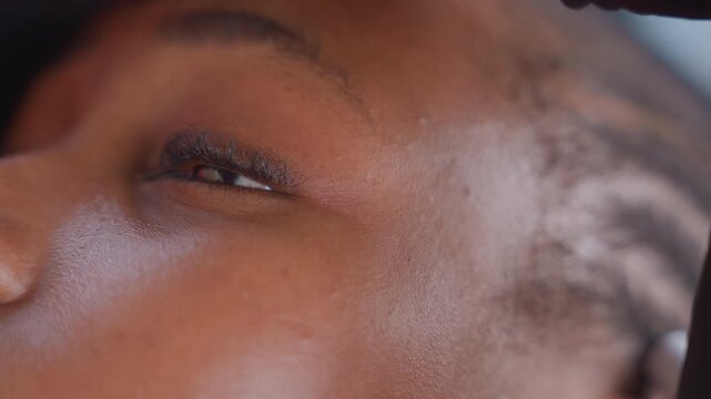 Female sprinter concentrating. Closeup of athlete preparing to run. Focused woman athlete ready to sprint intensely. Close shot capturing woman sprinter with determined expression and sweat