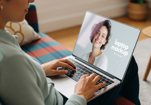 Close-up laptop screen mockup of woman using laptop at home on sofa