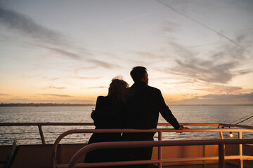 Obraz premium Silhouette of a couple on a boat deck at sunset