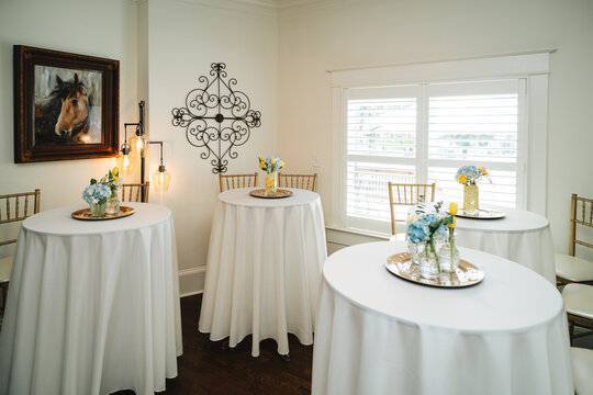 Elegant event reception setup with cocktail tables and floral centerpi