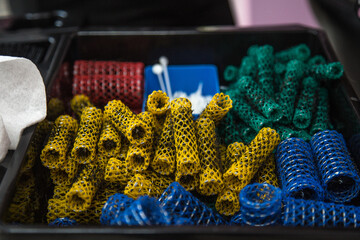 Assortment of colorful hair rollers in a salon tray, ready for styling