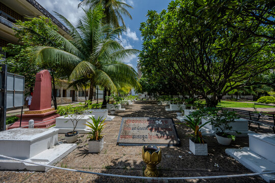 Memorial graves and trees at Tuol Sleng Genocide Museum courtyard in Phnom Penh