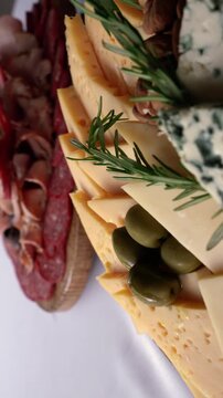 Cinematic close up of gourmet catering boards featuring fontina, gouda, tybo, gruyere and blue cheese with prosciutto, ham, pancetta, bondiola, salami, longaniza, olives and almonds for elegant events