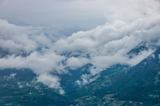 Scenic view into Ultental Valley with low clouds around alpine peaks in South Tyrol, Italy