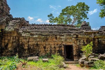 Fototapeta premium Ancient stone temple ruin with doorway and trees in Cambodia