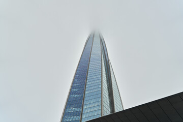 Urban highrise merges into cloudy sky with sleek modern design