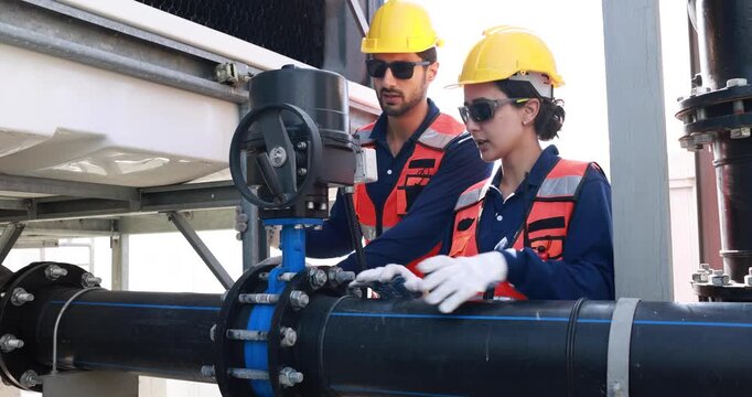 A male annd female engineer working on checking and maintenance equipment at industry solar rooftop power on sunset background.
