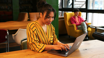 Confident successful woman, worker using laptop, checking mail, sitting on table, in coworking