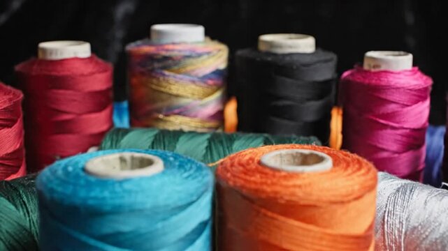 A vibrant collection of colorful sewing threads on spools arranged closely together, ready for