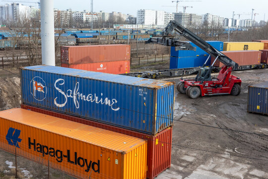 WARSAW, MAZOWIECKIE, POLAND - FEBRUARY 27, 2026: A red reach stacker works at a logistics terminal