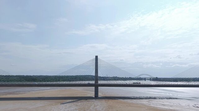 Liverpool, Merseyside, UK, June 19, 2025; Aerial 4K video footage of the Mersey Gateway toll bridge with stunning views over the River Mersey, Liverpool, UK.