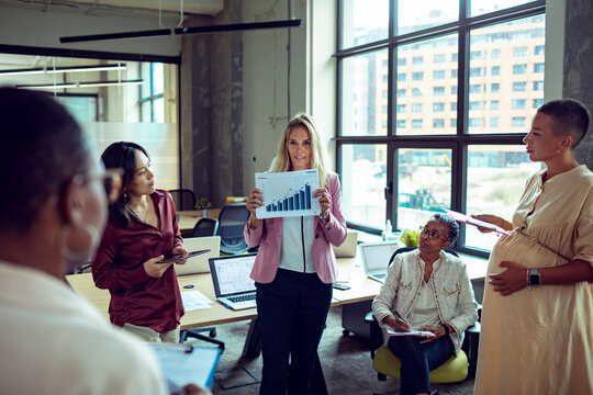 Diverse business team reviewing growth chart in modern office