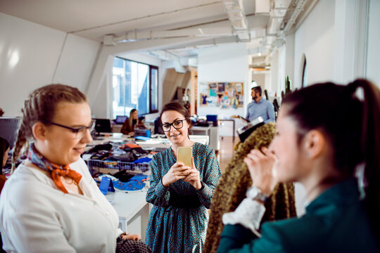 Fashion designers collaborating and taking photos in modern studio