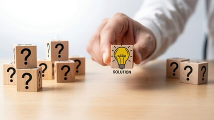 Naklejka premium Hand choosing wooden block with lightbulb symbol representing solution among blocks with question marks, problem solving concept