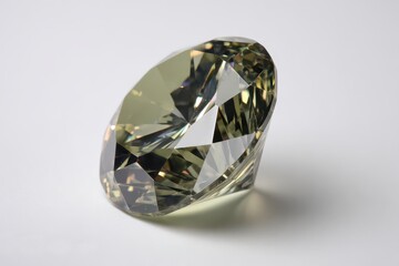Close Up of a Faceted Olive Green Diamond Stone on a White Background with Soft Lighting Reflecting Off Its Surface