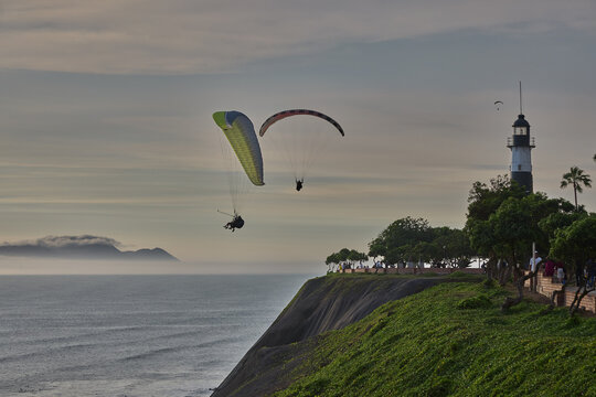 Paragliders soaring above the Malec&oacute;n of Miraflores in Lima, Peru, with coastal views and urban promenade, capturing an active lifestyle, authentic local culture, and modern city living. 
