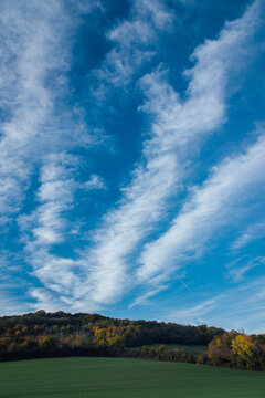 Paysage de campagne en automne avec un ciel bleu et des nuages blancs. Cirrus au dessus d'une for&ecirc;t. Paysage rural automnal. 