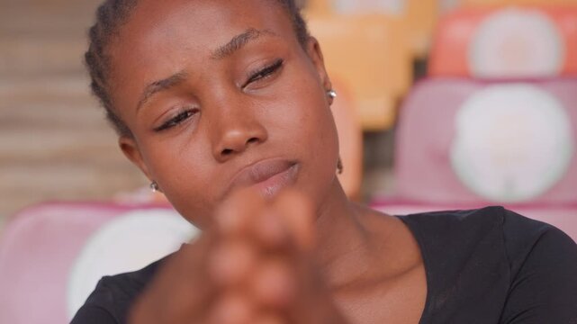 closeup young woman reaching forward with hands, thoughtful gaze and hopeful expression in bleacher setting, intimate portrait exploring connection and invitation, warm sunlight accentuating skin