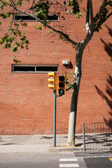 Green pedestrian traffic light and brown brick wall street background, Barcelona Spain