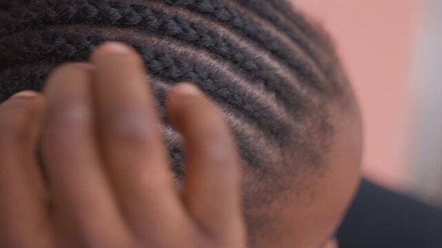 closeup black cornrows stylist hand inspecting, professional salon setting, thumb and fingers checking tension and neat parting, textured scalp detail, precise technique, clinical light