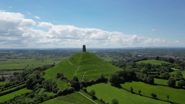 Aerial Flight Behind Glastonbury Tor Revealing Somerset Countryside and Patchwork Fields England UK