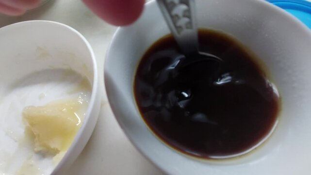 Adding a spoonful of natural honey into a cup of black coffee