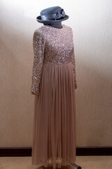 A beautiful women's dress on a mannequin with a hat
