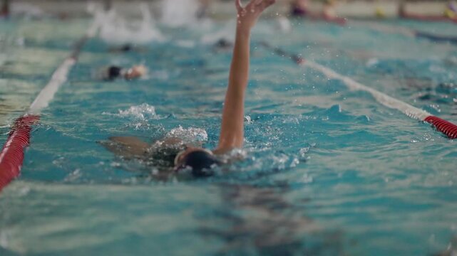 Professional swimmer training backstroke in a pool
