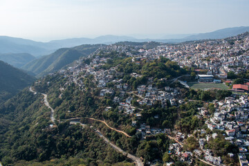 Obraz premium Wide panoramic view of Taxco, Guerrero, Mexico, nestled among green hills with its iconic hillside architecture