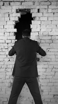 Individual Scrutinizes Cavity Behind Rough Bricks. Investigator Carefully Probes Cavity Amidst Smoky Urban Environment