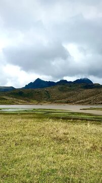 Yellow Meadows, Rolling Hills, and Shadowy Mountains Over Lake (Cotopaxi National Park, Ecuador)