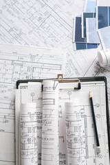 Architecture blueprints with rolled plans, compass and clipboard on desk, construction documentation and engineering design workflow,planning and project management concept, copy space.