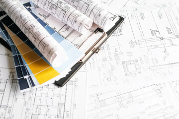 Architecture blueprints with rolled plans, compass and clipboard on desk, construction documentation and engineering design workflow,planning and project management concept, copy space.