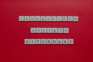 Generalized anxiety disorders text spelled with letter tiles and capsules on orange background. Mental health concept, stress, panic, and medical treatment theme. © Rio
