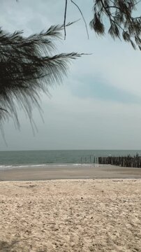 Tranquil shoreline featuring smooth surf and mild clouds