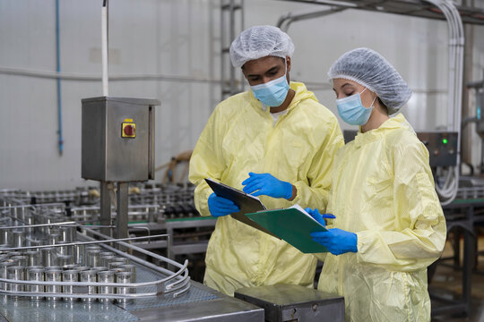 Canned fish factory. Conveyor belt for canned fish. Conveyor belt and workers. Production line of canned fish. Worker working and inspecting quality of seafood processing conveyor belts